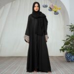Black Nidha open-front abaya with lace sleeve details and golden brooch – casual modest wear