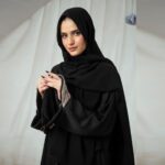 Black Nidha open-front abaya with lace sleeve details and golden brooch – casual modest wear
