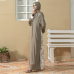 Model wearing Emerald Ruya Abaya in elegant emerald tone with gold clasp detailing and printed cuffs, styled with matching scarf.