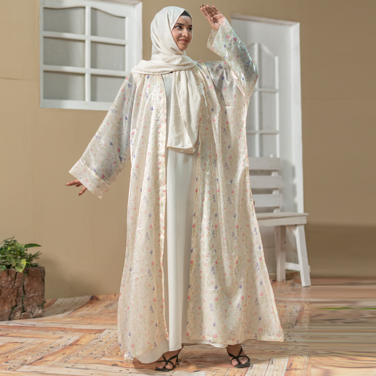 Model wearing Luna Flora Abaya coat set with pastel floral printed outer layer and cream inner dress styled with matching hijab.