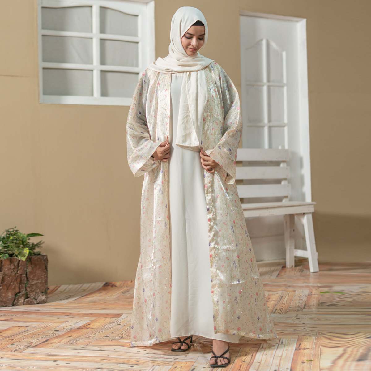 Model wearing Luna Flora Abaya coat set with pastel floral printed outer layer and cream inner dress styled with matching hijab.